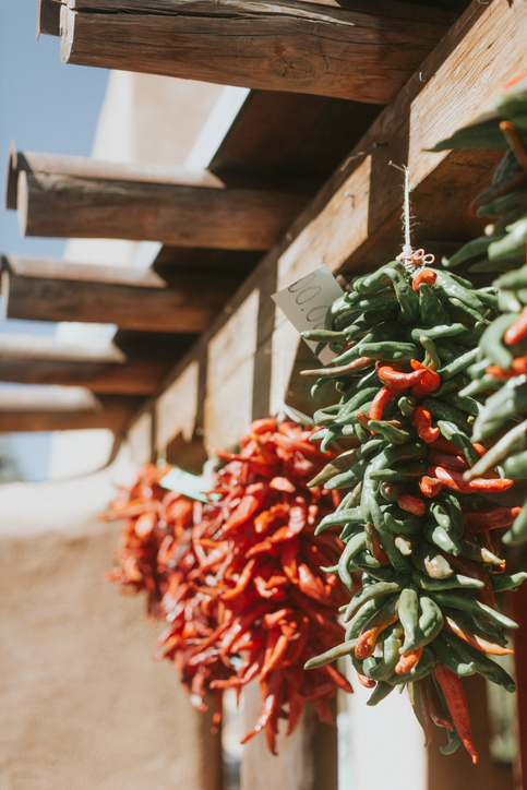 Red and Green Chili peppers in Albuquerque New Mexico against the adobe pueblo. Hanging out to dry in the sun.